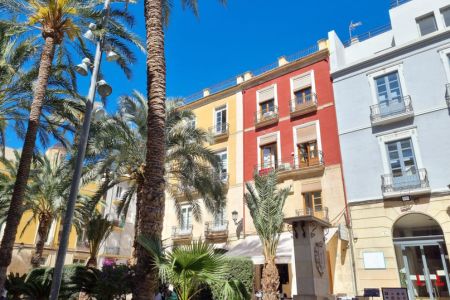 Bunte Häuserfassaden und Palmen in Alicante.