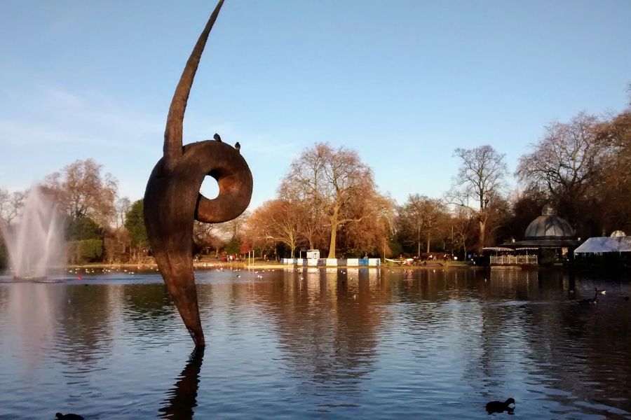 Der West Lake im Londoner Victoria Park mit Fontäne und Skulptur sowie im Hintergrund dem Pavilion Café.