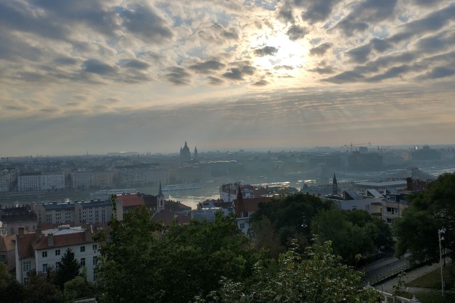 Blick auf Budapest, während sich die Sonne den Weg durch die Wolken bahnt.