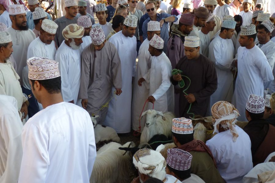 Einheimische, Touristen und Ziegen auf dem Viehmarkt in Nizwa, Oman.