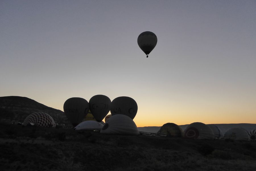 Ein Heißluftballon steigt auf, noch bevor die Sonne aufgegangen ist.