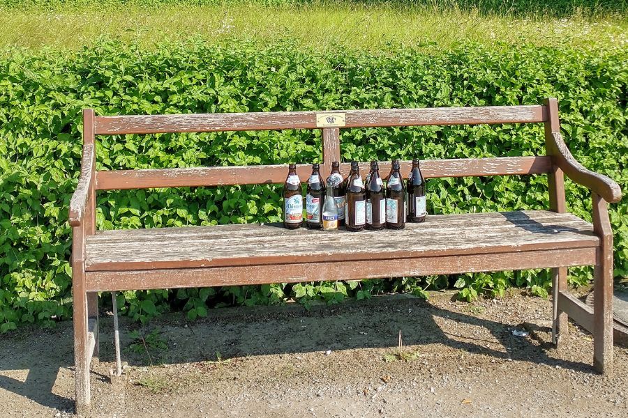 Leere Bierflaschen auf einer Parkbank.