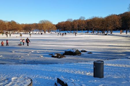 Schlittschuhläufer auf dem zugefrorenen See im Westpark.