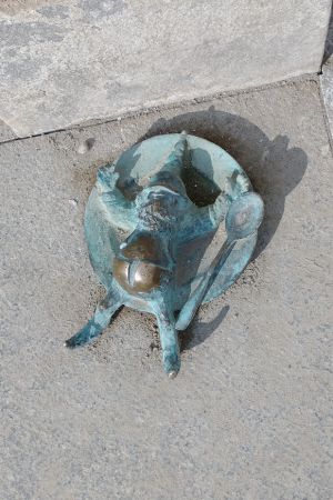 Ein vollgefressener Bronzezwerg mit Kugelbauch streckt in Breslau alle Viere von sich.