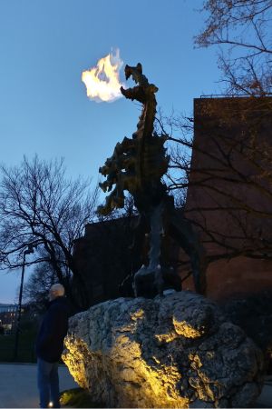 Der Drache am Fuß des Wawelschlosses spuckt in der Dunkelheit Feuer.