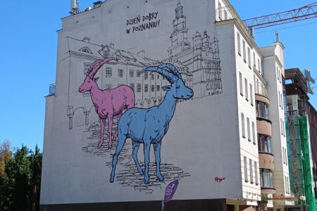 Wandmalerei von zwei Ziegen vor angedeuteter Fassade mit der polnischen Aufschrift "Guten Tag in Posen".