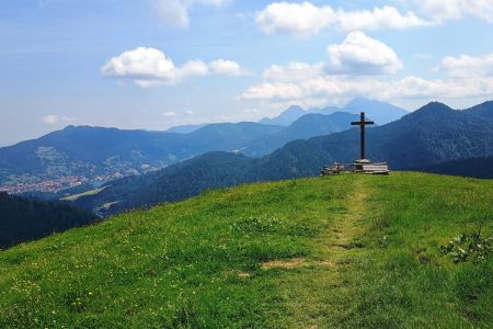 Das Kreuz der Kreuzbergalm, im Hintergrund der Ort Schliersee.