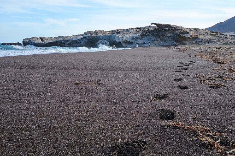 Fußspuren am Strand von Los Escullos, im Hintergrund der Felsüberhang.