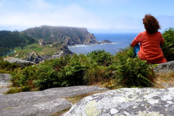 Julia Pracht sitzt auf einem Felsen auf den Illas Cíes und schaut aufs Meer.